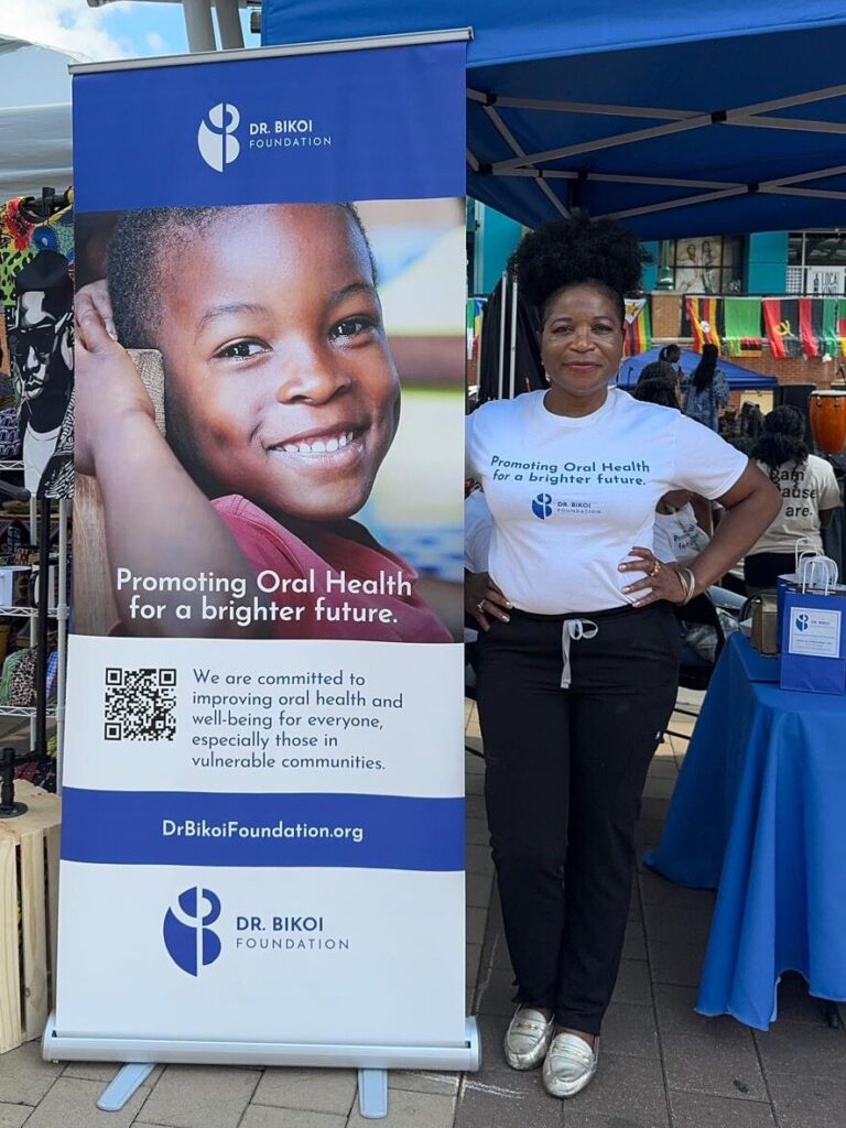 Dr. Bikoi standing next to event sign